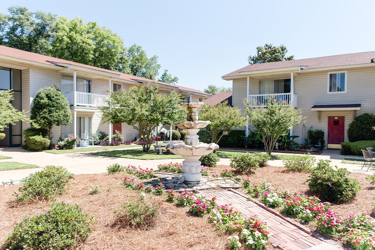 Beautiful outdoor view of a property with a decorative fountain and colorful flowers, representing Red Rock Realty Group's residential property management services.